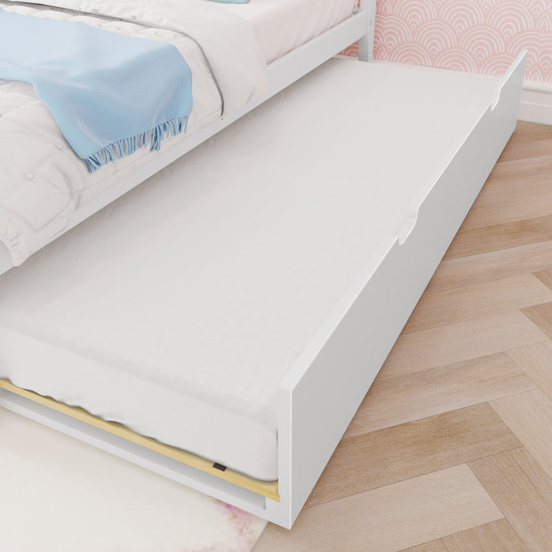 White kids trundle bed with pull-out mattress, blue throw blanket, pink patterned wallpaper and hardwood floor