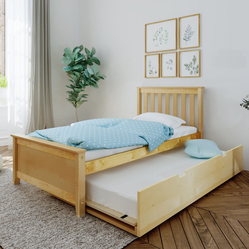 Solid wood single bed with pull-out trundle, light blue polka-dot duvet, fiddle leaf fig plant and botanical wall art