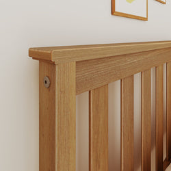 Close-up of oak wooden slatted headboard mounted on a white bedroom wall with framed art, modern rustic bedroom decor and furniture detail