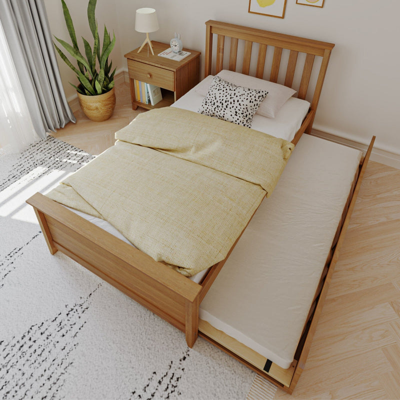 Sunlit minimalist bedroom featuring a modern wooden single bed with space-saving pull-out trundle mattress, yellow duvet, spotted throw pillow, wooden nightstand and potted plant