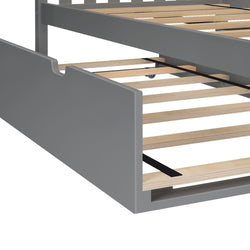 Gray painted wooden platform bed frame with natural plywood slats and pull-out under-bed trundle storage drawer on casters