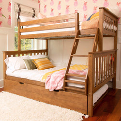 Solid wood twin-over-full bunk bed with ladder and under-bed storage drawer in kids bedroom with pink pineapple wallpaper and cozy yellow-and-pink bedding