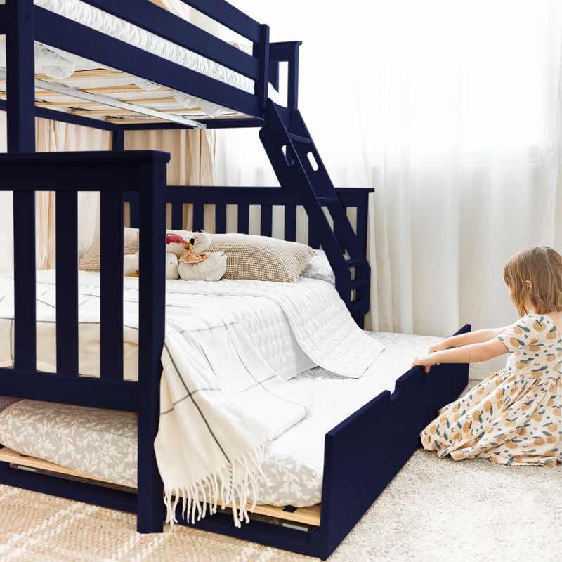 Navy blue wooden bunk bed with ladder and pull-out trundle, white bedding and plush toys in a bright space-saving kids bedroom