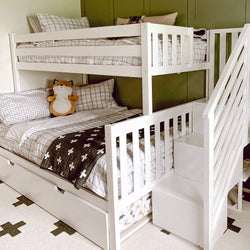 White wooden bunk bed with storage stairs in a kids' room with green wall, featuring cozy bedding and a cute stuffed animal, perfect for maximizing space in small bedrooms.