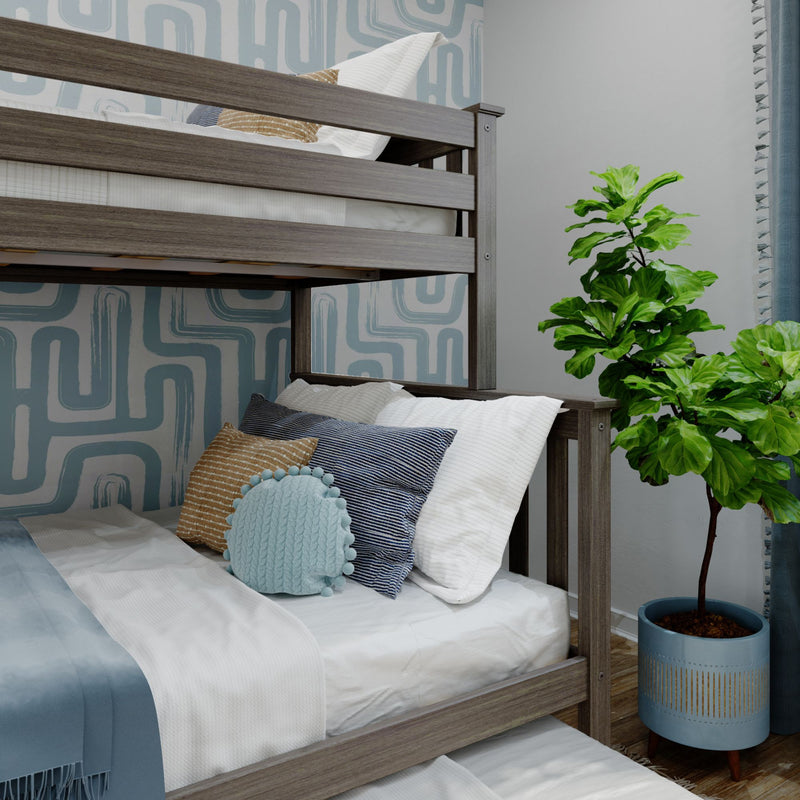 Gray wooden bunk bed with white and blue bedding and decorative pillows against blue geometric wallpaper in a modern kids' bedroom with a potted fiddle leaf fig plant