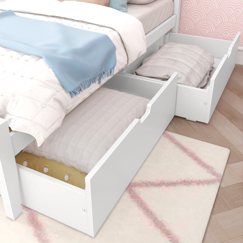 White wooden bed with pull-out under-bed storage drawers, pastel pink quilt and blue throw blanket in a child's bedroom with pink scallop wallpaper