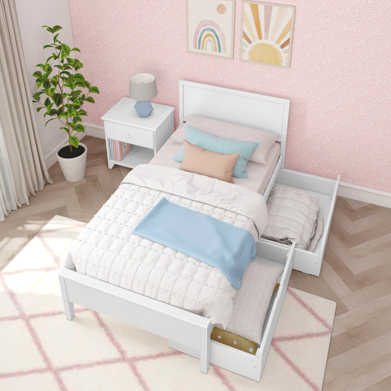 Pastel girls bedroom with white twin bed and under-bed storage drawer, pink patterned wallpaper, nightstand with lamp, pastel pillows and potted plant
