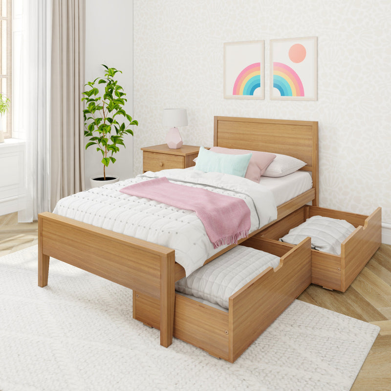 Modern minimalist bedroom with wooden platform bed and under-bed trundle storage drawers, white quilted bedding, pink throw and pastel pillows, wooden nightstand with lamp, potted plant and rainbow wall art