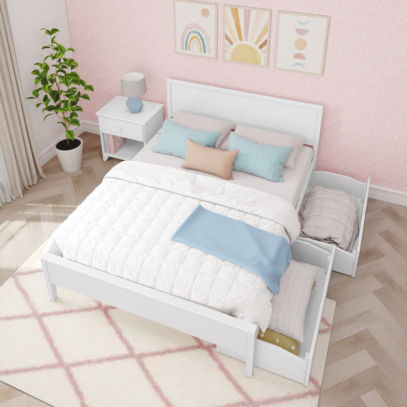 Cozy pastel girls bedroom with white wooden trundle bed and under-bed drawers, pink patterned wallpaper, pastel pillows, nightstand lamp and rainbow wall art