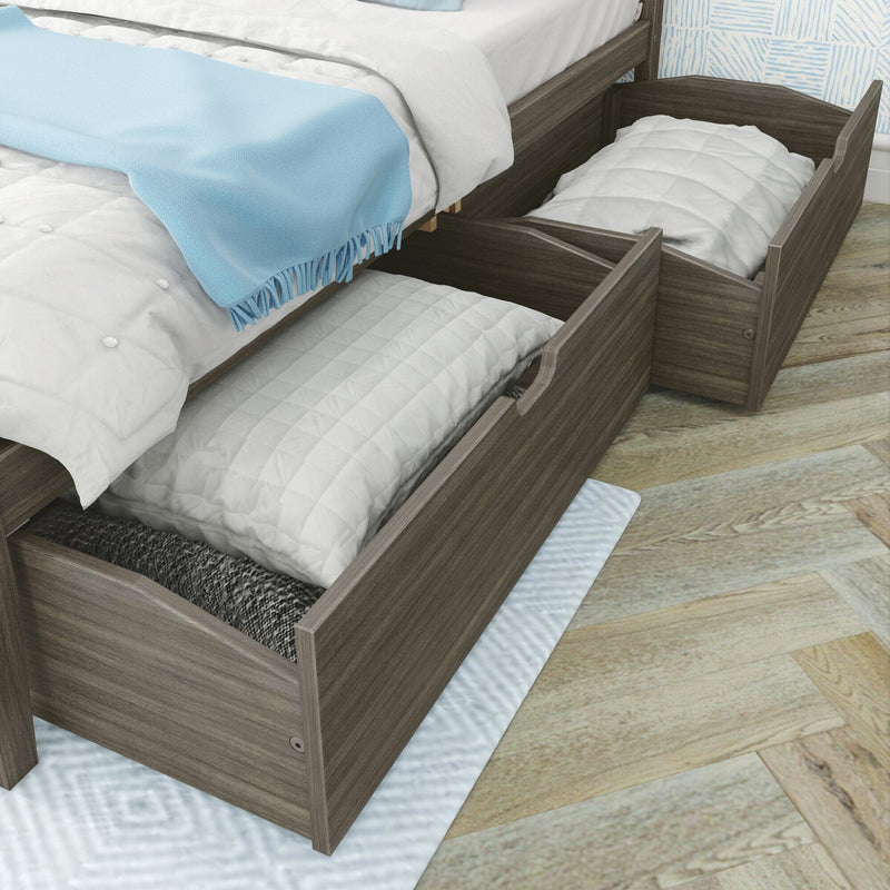 Grey wood platform bed with two pull-out under-bed storage drawers holding pillows and quilts, light-blue throw on bed, hardwood floor, space-saving bedroom organization