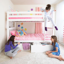 Children playing in a colorful bedroom with a white bunk bed and pink bedding.