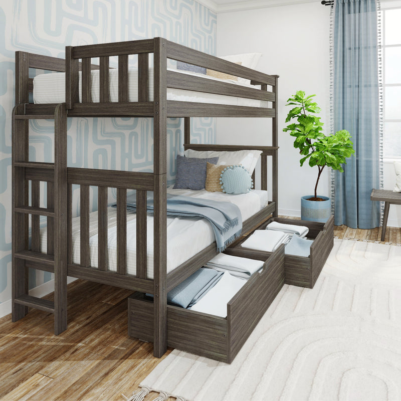 Gray wood twin-over-twin bunk bed with built-in under-bed storage drawers and ladder in a coastal-style kids bedroom with blue pillows, light blanket, patterned wallpaper and potted plant