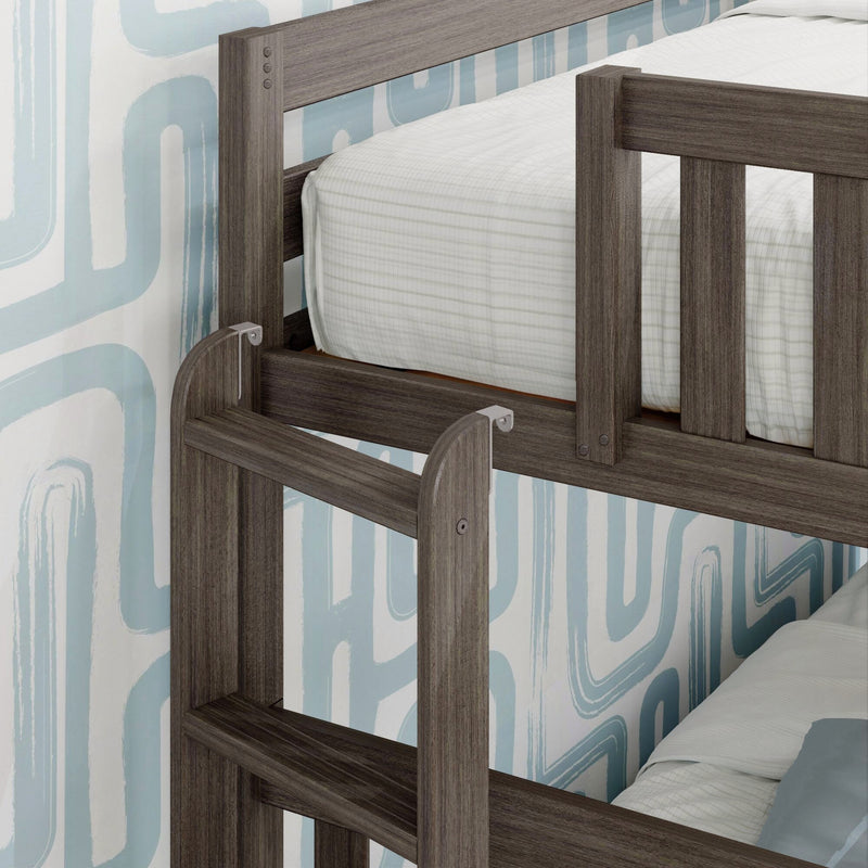 Close-up of grey wood bunk bed guardrail and ladder with white striped mattress in children's bedroom against blue retro geometric wallpaper