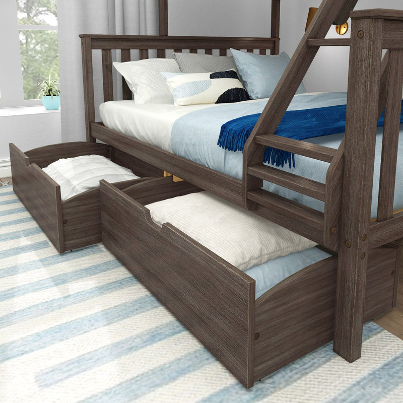 Rustic gray wooden kids' bunk bed with pull-out trundle storage drawers, light blue bedding, decorative pillows and ladder by window