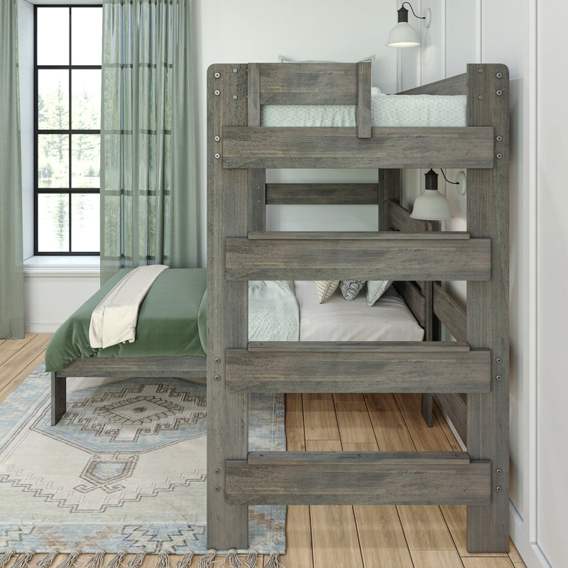 Rustic gray twin-over-twin bunk bed with green bedding, sheer curtains and black-framed window, wall sconce and patterned rug on hardwood floor in modern farmhouse bedroom