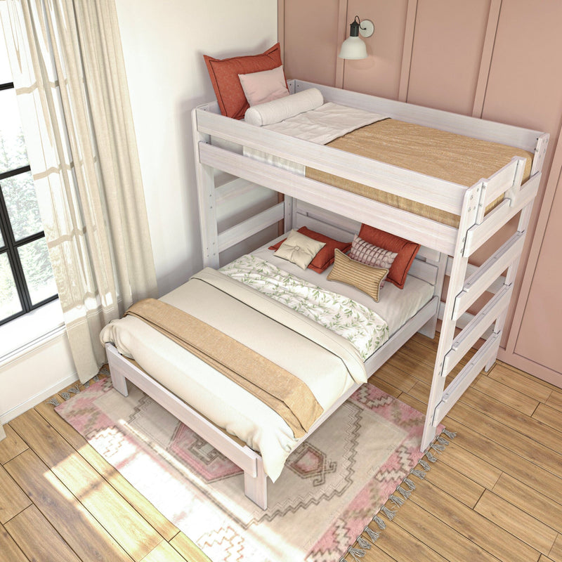 White wooden twin-over-full bunk bed in cozy boho bedroom with blush accent wall, layered neutral bedding, patterned rug and natural window light