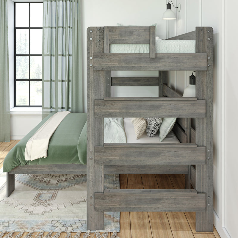 Rustic gray wooden twin-over-twin bunk bed in bright modern farmhouse bedroom with green bedding, patterned pillows, area rug and window with green curtains
