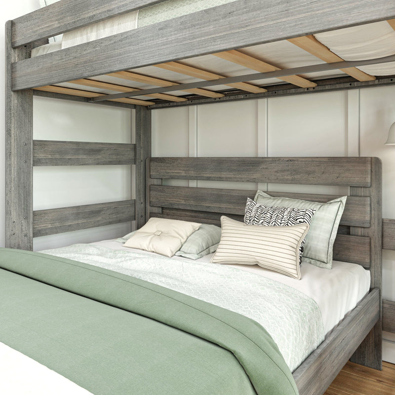 Close-up of rustic gray wooden bunk bed with slatted mattress support, mint-green comforter and decorative pillows