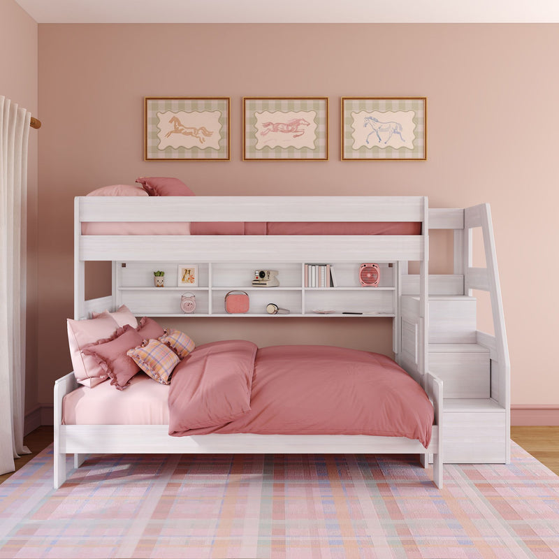 White twin-over-full wooden bunk bed with storage stairs, built-in shelves and pink bedding in a girl's bedroom with plaid rug and framed horse prints