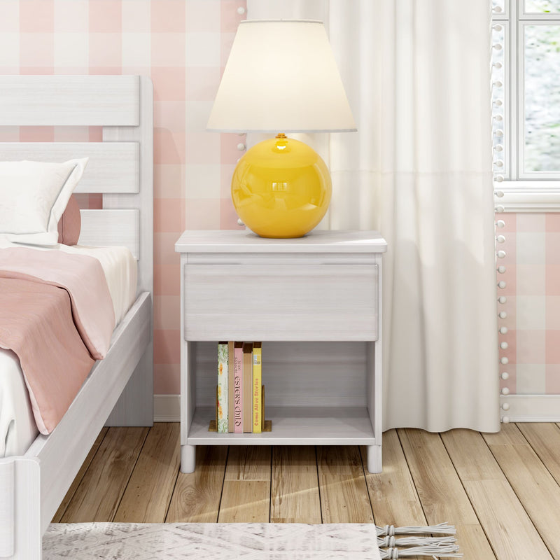 Yellow table lamp on white wood nightstand with books, pink gingham wallpaper and white bedding in cozy modern bedroom