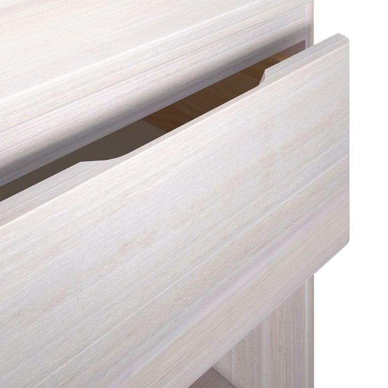 Close-up of whitewashed wood dresser drawer with recessed finger-pull handle on modern minimalist bedroom furniture
