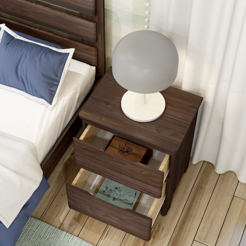 Modern walnut nightstand bedside table with white globe lamp and two open drawers revealing books beside an upholstered bed on hardwood floors