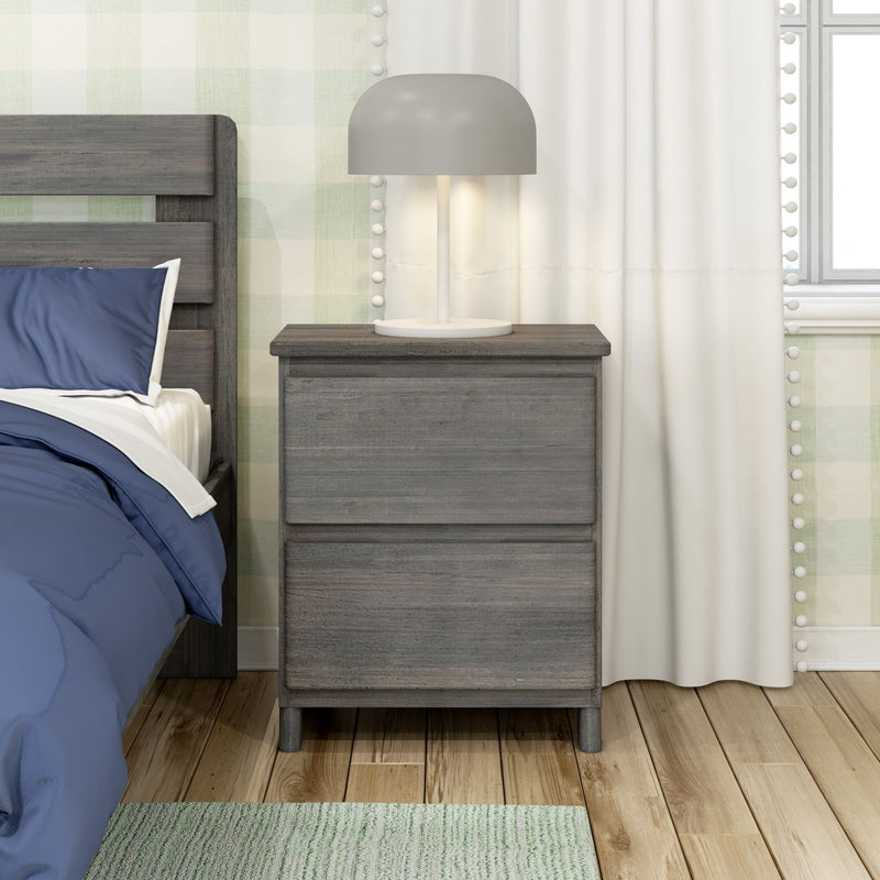 Modern gray two-drawer wooden nightstand with lamp beside bed with blue bedding, white curtains and green plaid wallpaper on hardwood floor