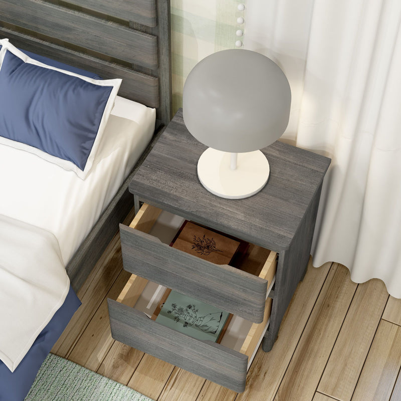 Modern gray wooden nightstand bedside table with round white lamp and two open drawers containing books, beside bed with navy pillow on hardwood floor, bedroom decor