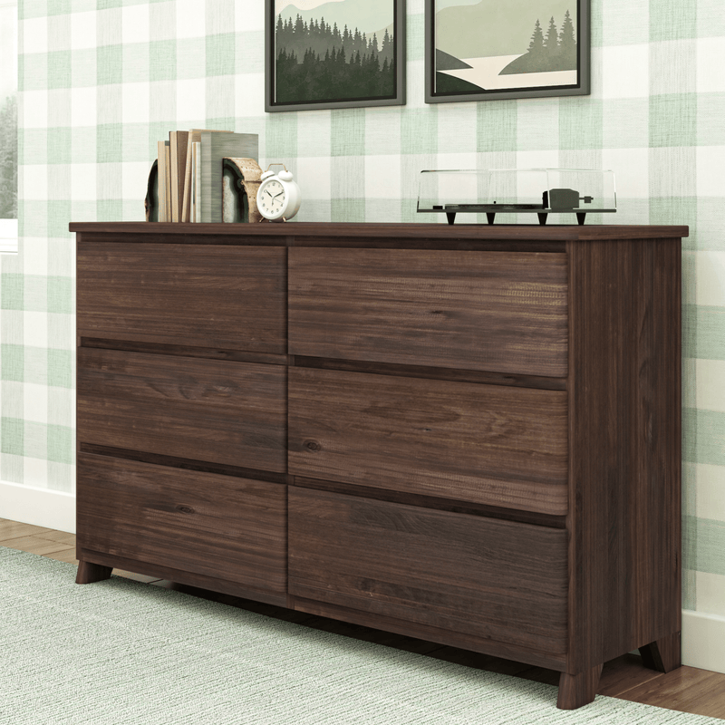 Mid-century modern dark walnut six-drawer wood dresser for bedroom storage, styled with books, a white alarm clock and a turntable against green plaid wallpaper