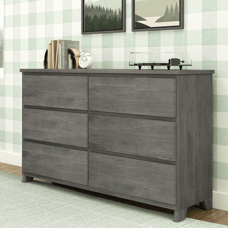 Gray wooden six-drawer dresser in modern bedroom with green plaid wallpaper, styled with books, white alarm clock and record player — contemporary bedroom storage chest