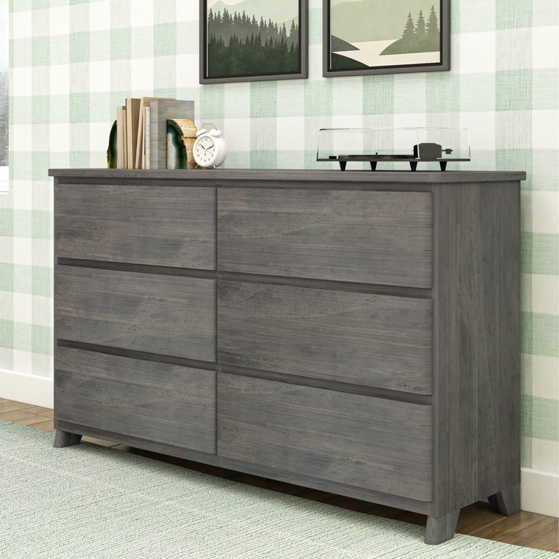 Modern gray wood bedroom dresser with mid-century legs against green plaid wallpaper, styled with books, agate bookend, white alarm clock and clear vinyl turntable