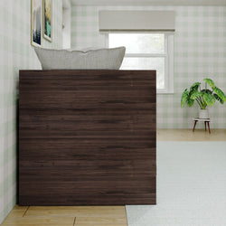 Stylish modern bedroom with dark wooden bed, patterned cushion, plant decor, and scenic wall art.