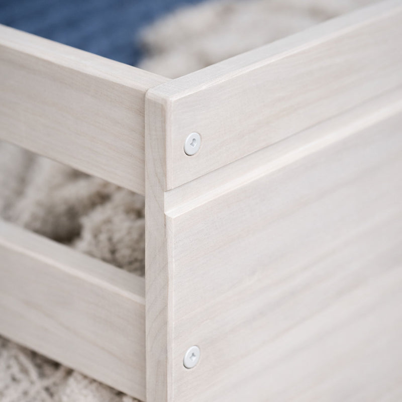 Close-up of whitewashed wooden storage crate corner with slatted panels, visible screw and natural wood grain