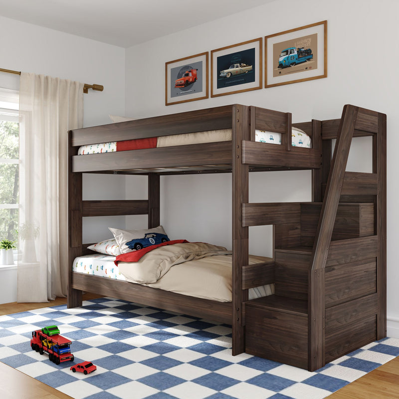 Dark wood loft bunk bed with staircase in a children's bedroom, car-themed bedding and framed car prints, blue checkered rug and toy cars.
