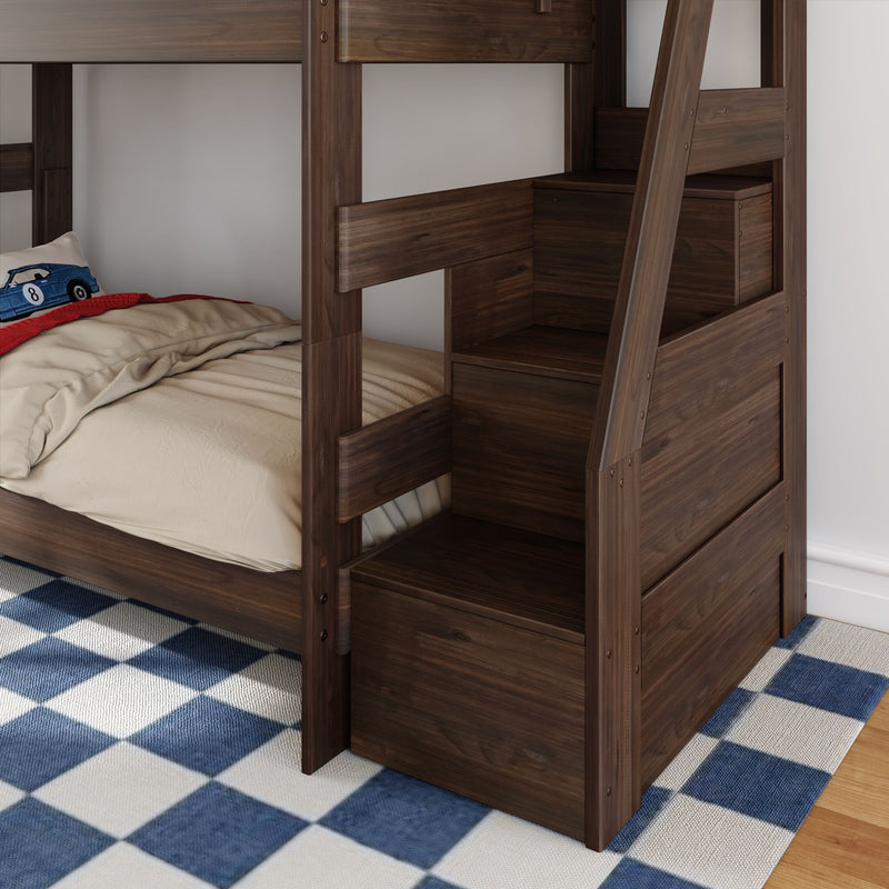 Dark walnut wooden bunk bed with built-in storage stairs and drawers, beige bedding with blue race car pillow on lower twin, navy blue checkered rug
