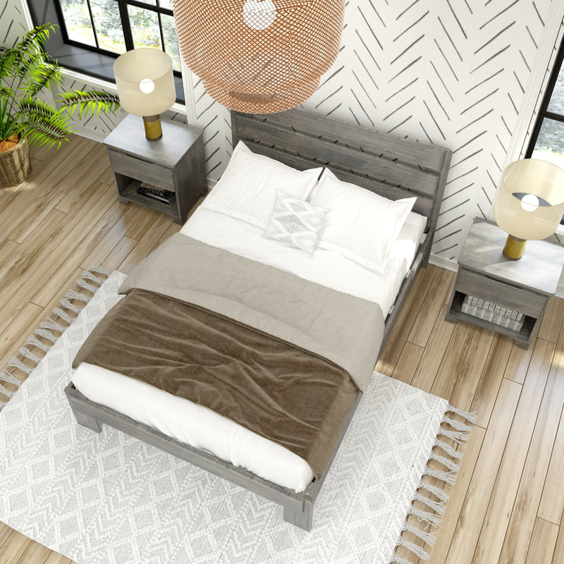 Top-down view of a modern farmhouse bedroom with a gray wooden bed, neutral bedding and throws, rattan pendant light, matching nightstands with lamps, potted plant, patterned rug and hardwood floors