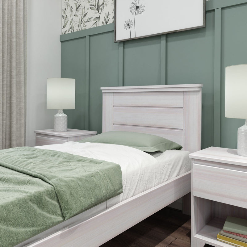Modern bedroom with whitewashed wooden bed and nightstand, green bedding, board-and-batten accent wall and bedside lamps