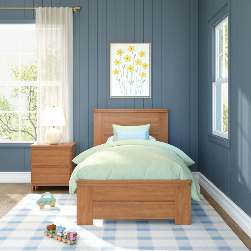 Cozy child's bedroom with wooden twin bed, pastel green bedding, blue paneled walls, framed yellow floral art, sheer curtains, bedside lamp, and wooden toy train on a blue check rug