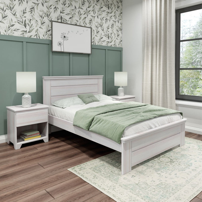 Sage green bedroom with botanical wallpaper, whitewashed wood bed and nightstands, green bedding, table lamps, hardwood floor and light curtains