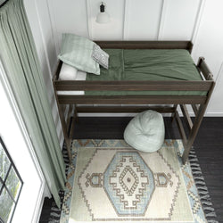 Loft bed with green bedding and decorative rug in cozy bedroom setting.