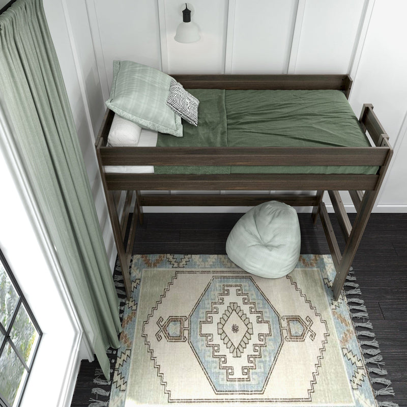 Dark wood loft bed with green bedding, patterned area rug, pale green curtains and beanbag in a cozy modern kids' bedroom