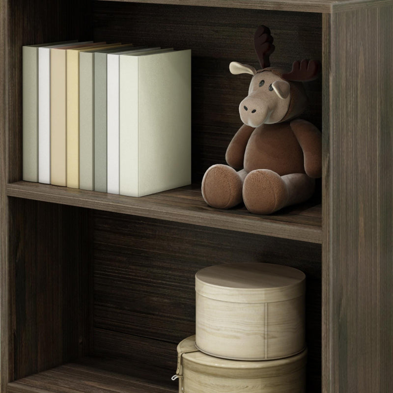 Bookshelf with books, brown plush toy, and round storage boxes.