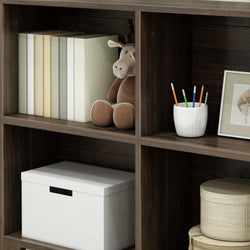 Cozy home office shelf with books, plush toy, and organized stationery in neutral tones.