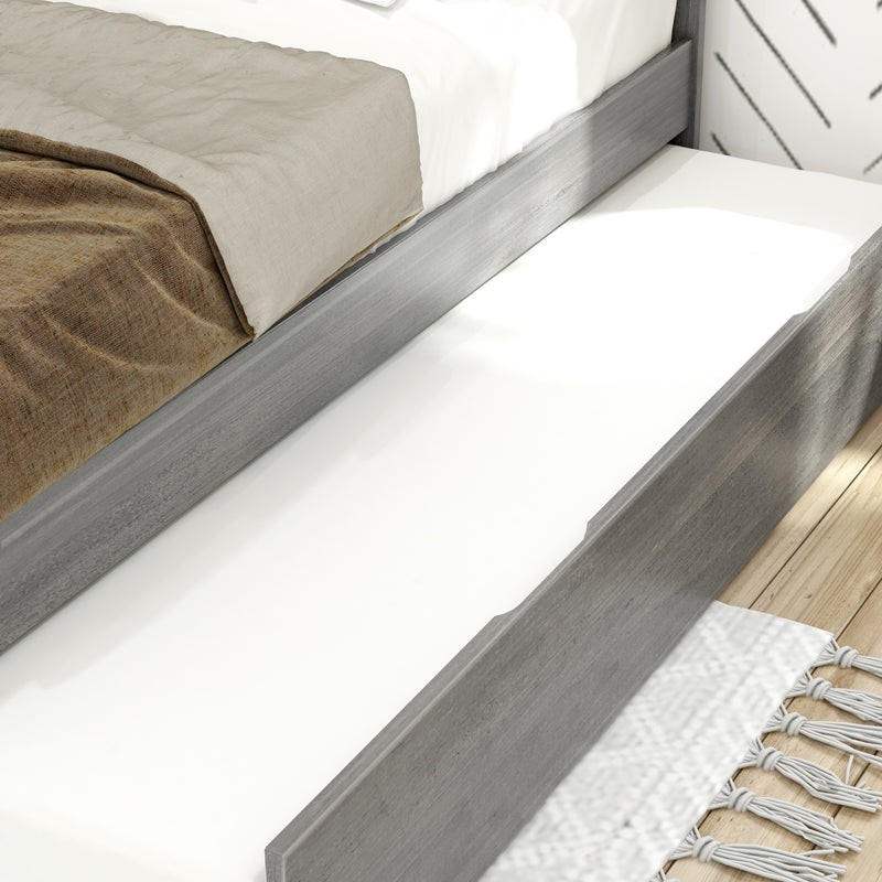 Close-up of gray wood platform bed with neutral beige and brown linen, white mattress and pull-out trundle on light hardwood floor