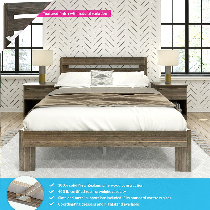 Solid pine platform bed with textured wood finish, slatted headboard, matching nightstands and lamps in a modern farmhouse bedroom with neutral bedding and herringbone wallpaper