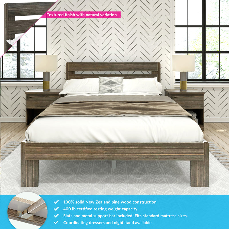 Rustic gray-wash solid pine bed frame with matching nightstands, neutral bedding and lamps, chevron textured wallpaper and large black-framed windows in a modern farmhouse bedroom