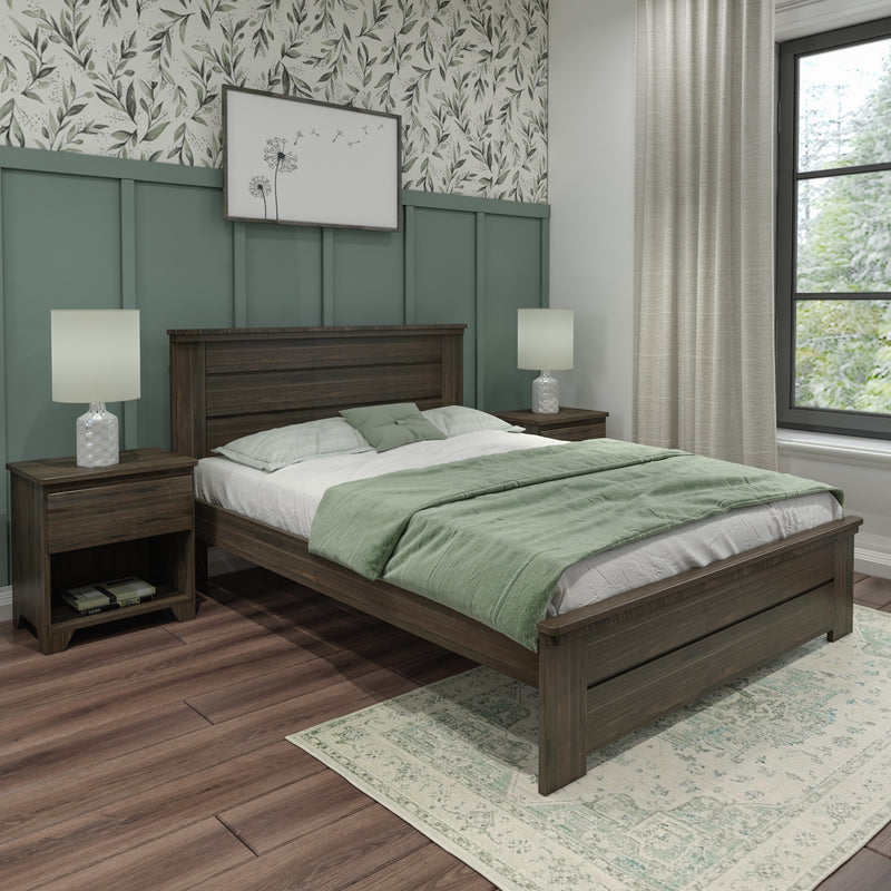 Modern farmhouse bedroom with dark wood platform bed, sage green bedding and throw, matching nightstands and lamps, green paneled accent wall with botanical wallpaper, wood flooring and patterned area rug