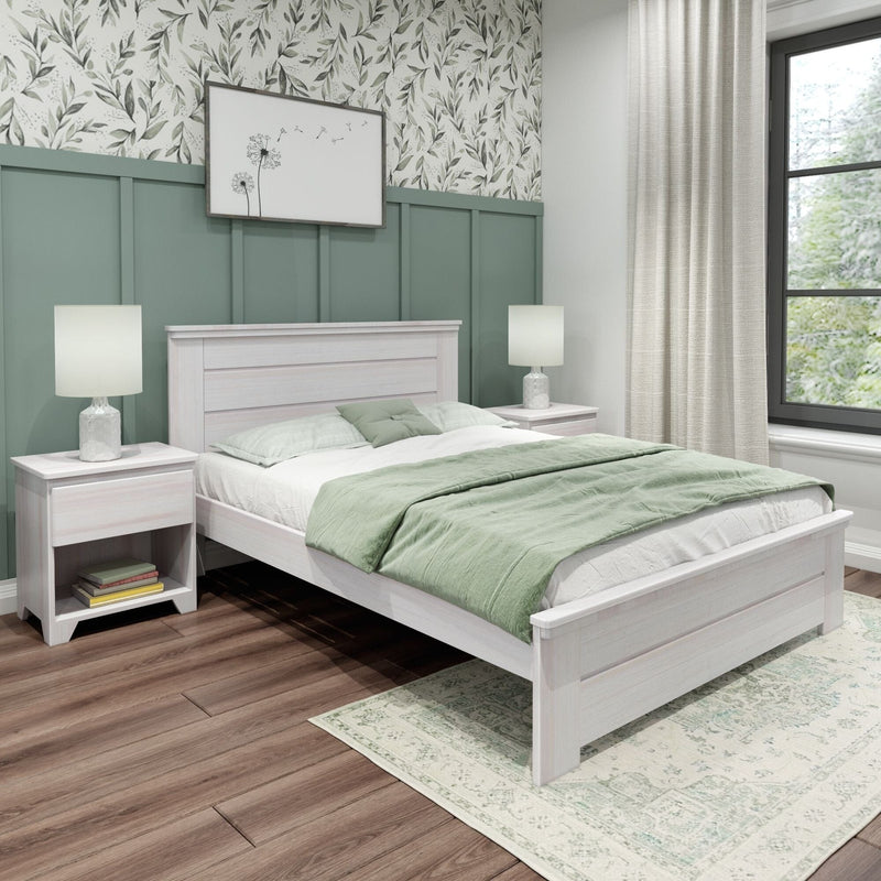 Modern farmhouse bedroom with green board-and-batten accent wall, whitewashed wood bed, sage green bedding, matching nightstands and lamps, floral wallpaper, sheer curtains and hardwood floors