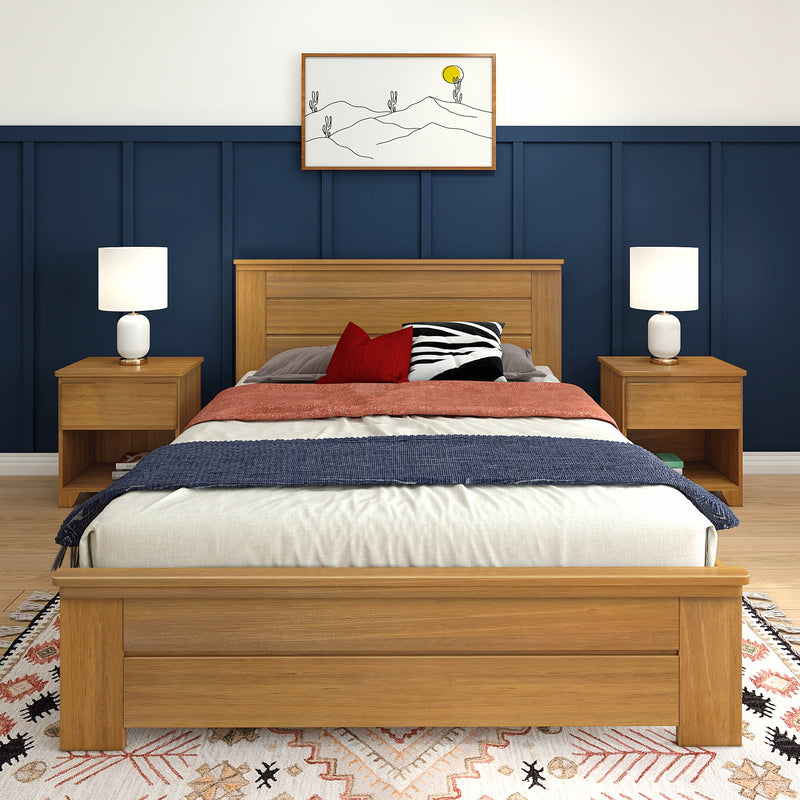 Modern bedroom with navy paneled accent wall, wooden bed frame and nightstands, white table lamps, red and zebra-print pillows, coral throw and framed minimalist desert wall art.