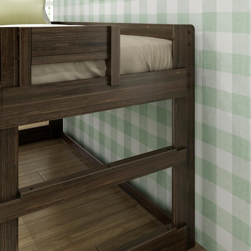 Close-up of dark wood bunk bed frame with guard rails, beige mattress and green plaid wallpaper in a children's bedroom